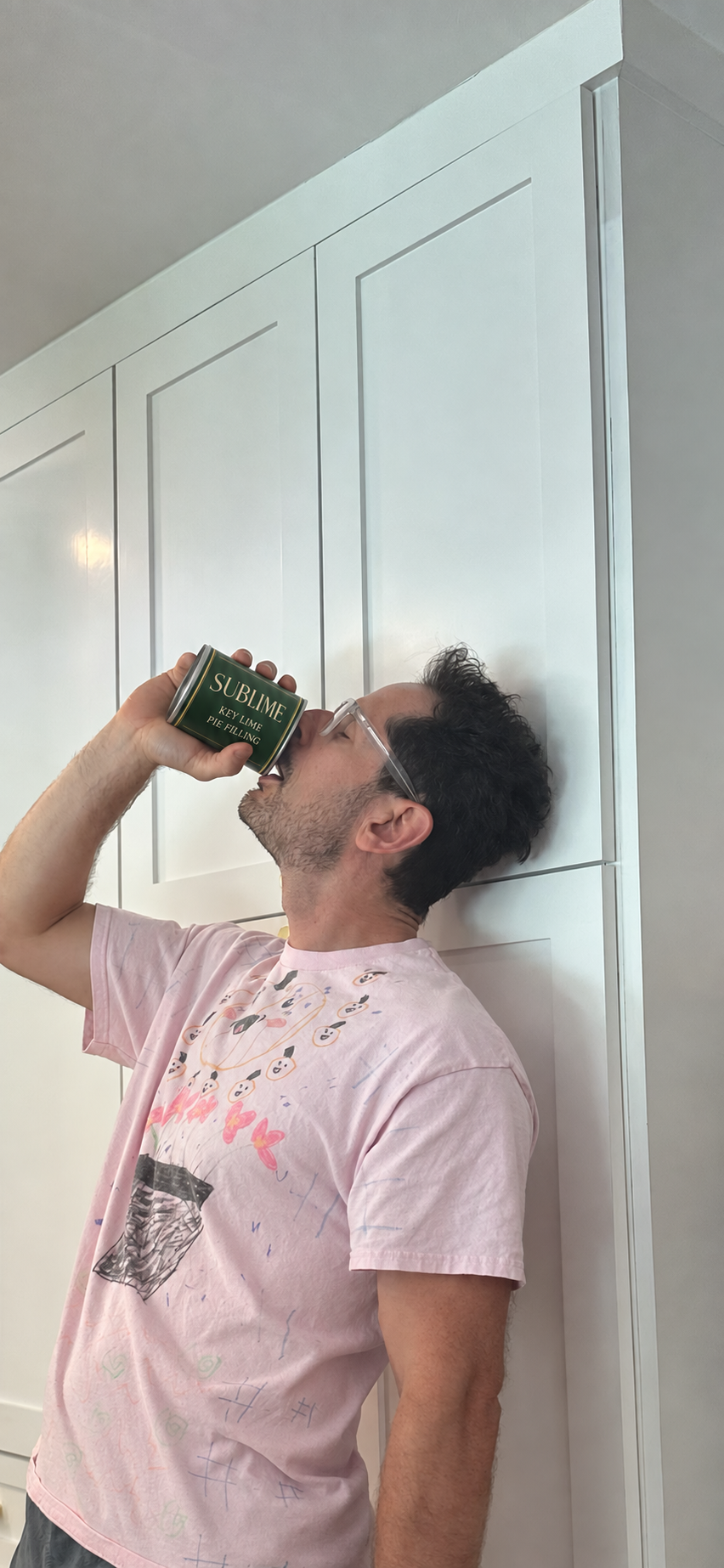 A man savors key lime pie filling directly from a forest-green Sublime can.
